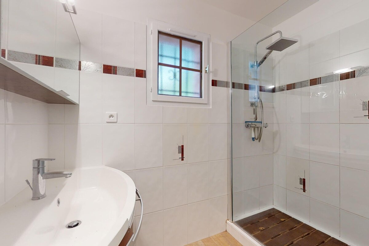 A bathroom with a sink and a walk in shower