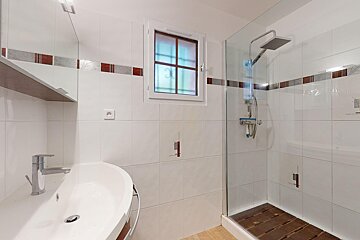 A bathroom with a sink and a walk in shower