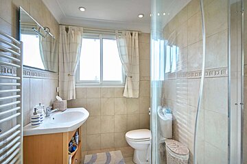 A bathroom with a toilet a sink and a window