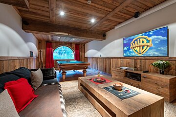 A room with a pool table and a tv that says warner bros