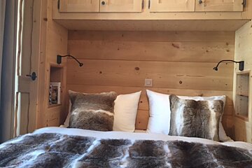 A bed with a fur blanket and pillows on it