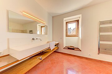 A bathroom with a large sink and a window