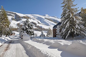 A snowy landscape with a building in the background