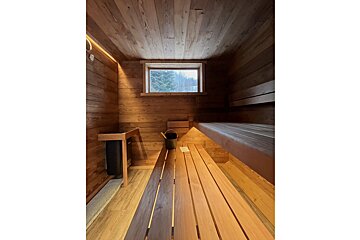 A wooden sauna with a window in the corner