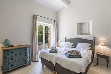 A bedroom with two beds and a blue dresser