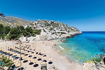 A beach with lots of umbrellas and chairs