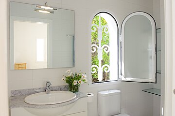 A bathroom with a sink and toilet and a window