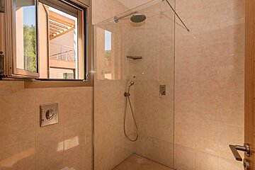 A bathroom with a walk in shower and a window