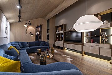 A living room with a blue couch and yellow pillows