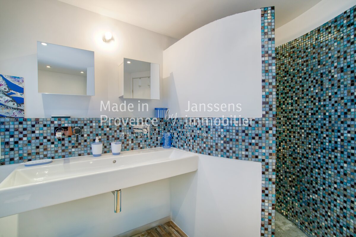 A bathroom with blue tiles and the words made in janssens provence
