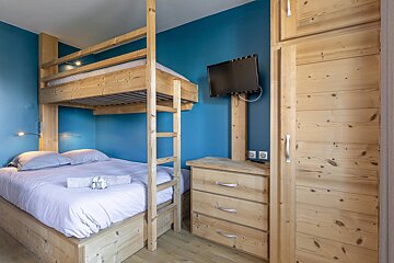 A bedroom with bunk beds and a flat screen tv