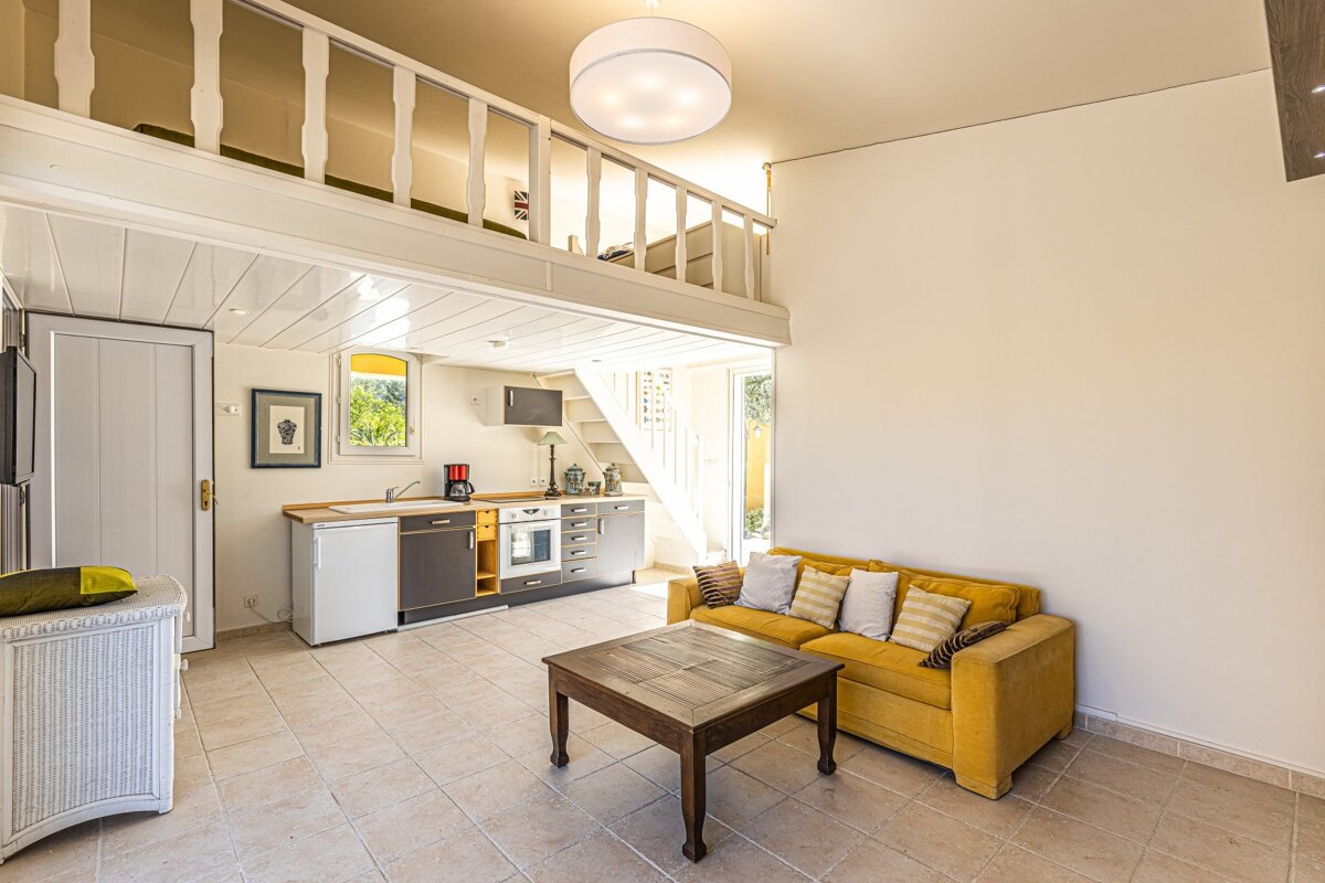 A living room with a yellow couch and a wooden table