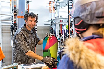 A man holding a snowboard that says ' salomon ' on it