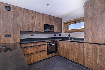 A kitchen with wooden cabinets and black counter tops