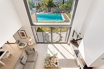 A living room with a view of a swimming pool