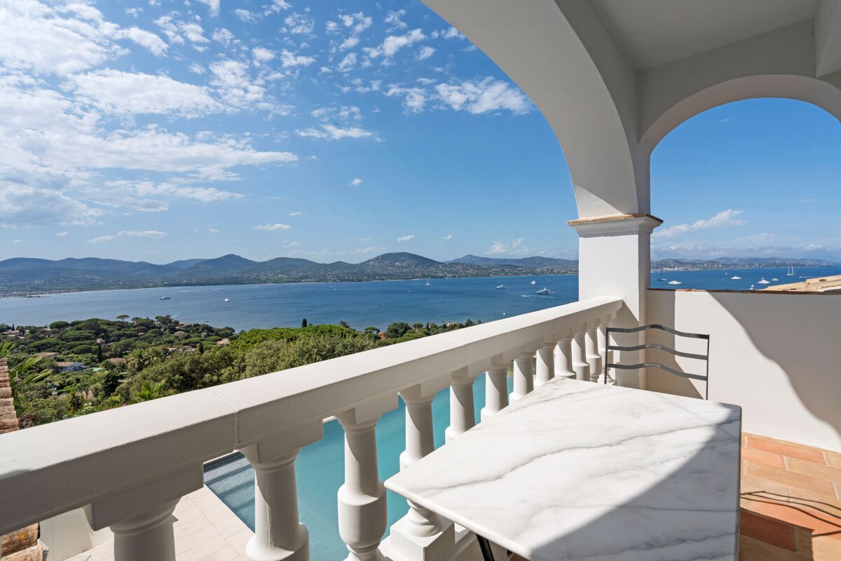 A balcony overlooking a body of water with mountains in the background