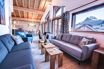 A living room with a couch and a table with a bottle of champagne on it