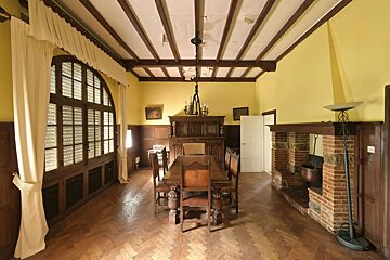 A dining room with a table and chairs and a fireplace