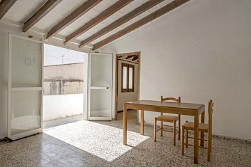 An empty room with a wooden table and chairs