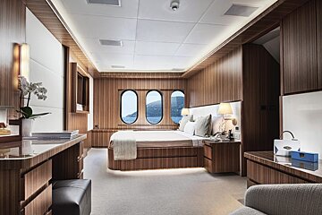 A bedroom with a large bed and two windows