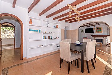 A dining room with a table and chairs and bookshelves