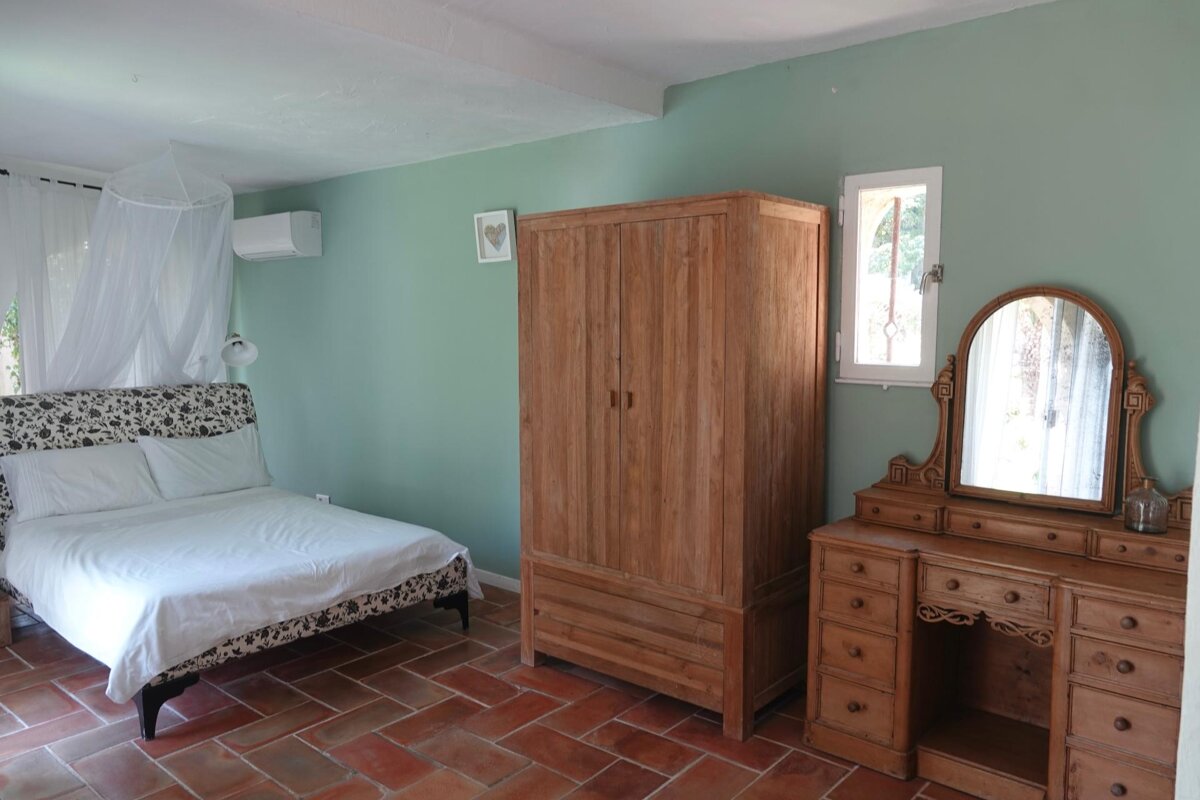 A bedroom with a bed dresser and a mirror