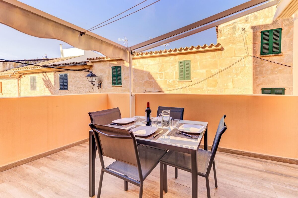 A table with four chairs and a bottle of wine on it