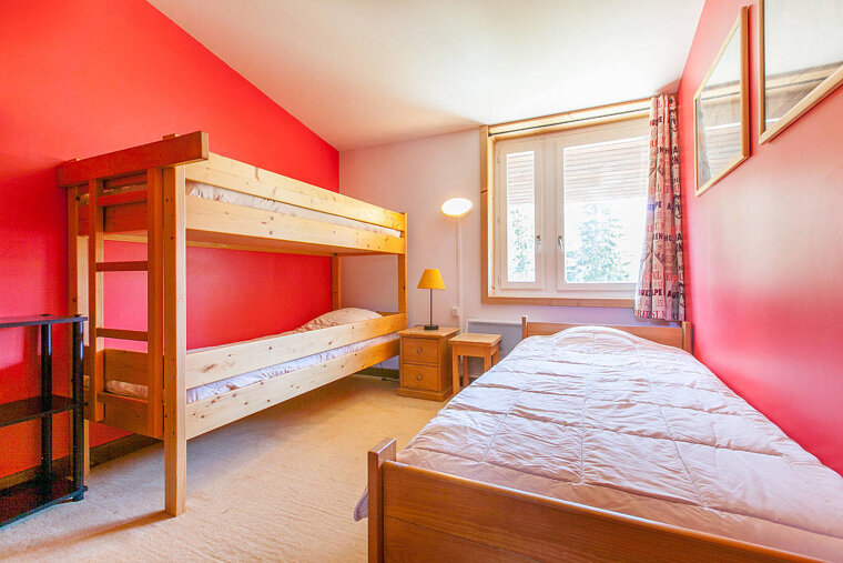 A bedroom with two bunk beds and a single bed