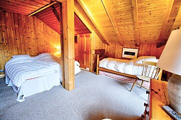 A bedroom with two beds and a lamp and a picture on the wall