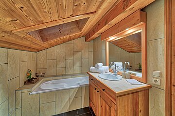A bathroom with a bathtub sink and mirror