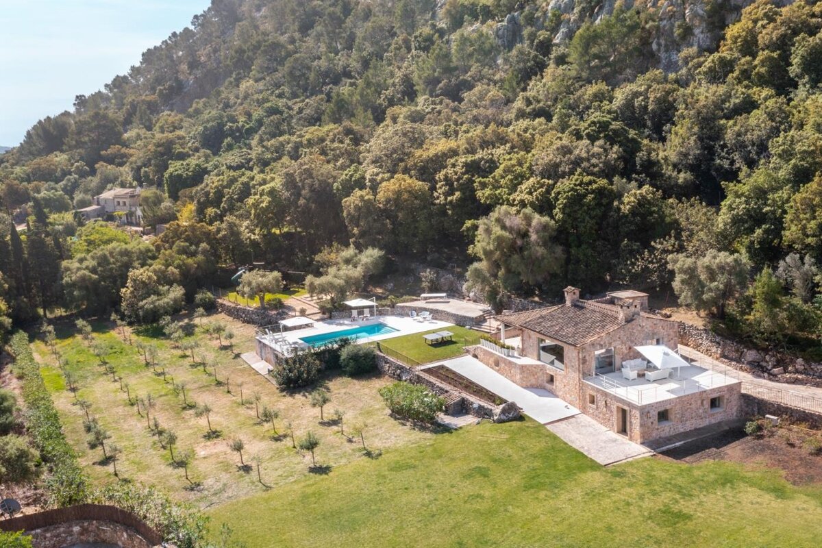An aerial view of a house with a large swimming pool