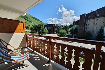 A balcony with two chairs and a view of mountains