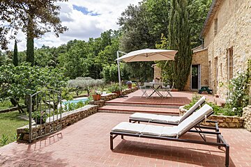 A patio with a table and chairs under an umbrella