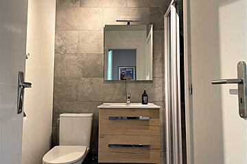 A bathroom with a toilet a sink and a mirror