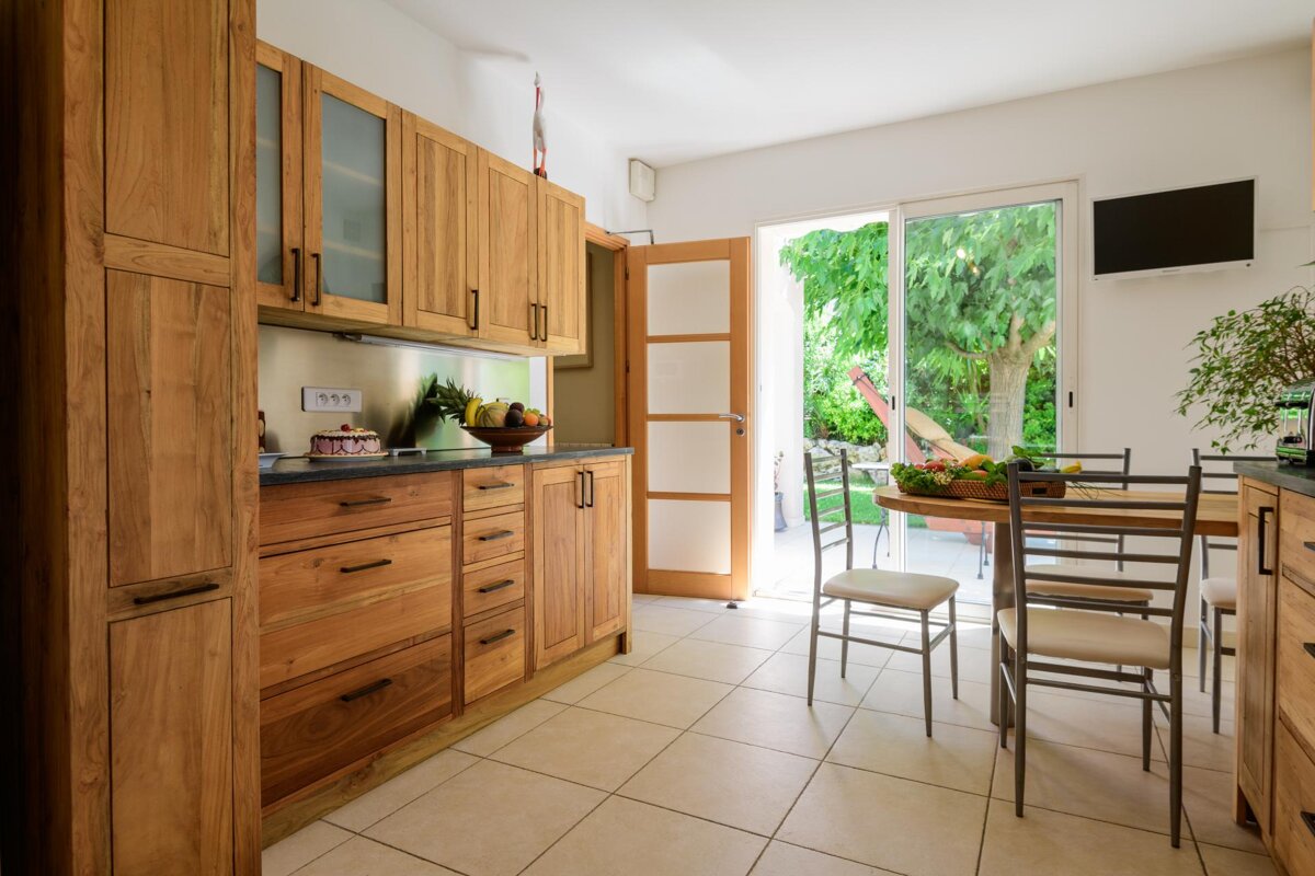 A kitchen with wooden cabinets and a sliding glass door