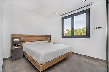 A bedroom with a large bed and a window