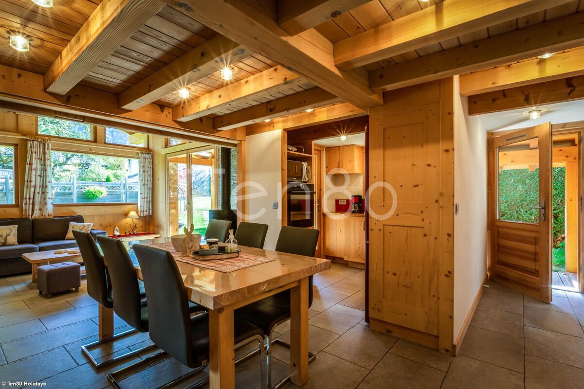 A wooden house with a dining table and chairs