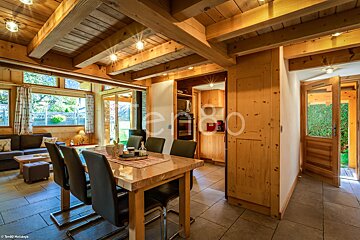 A wooden house with a dining table and chairs