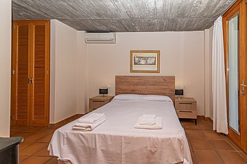 A bedroom with a picture on the wall above the bed