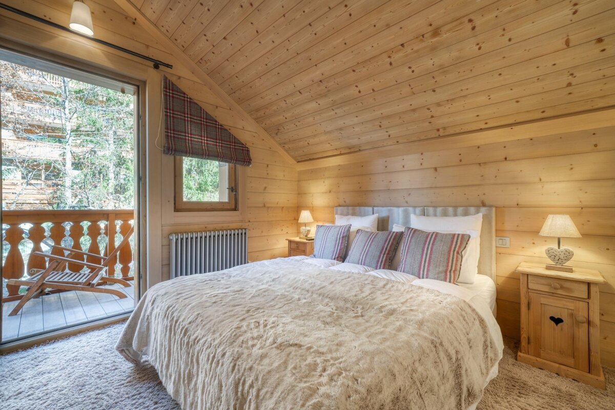 A bedroom with a large bed and a balcony