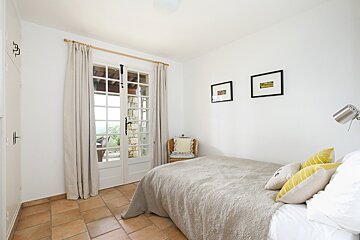 A bedroom with a single bed and a chair