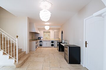 A kitchen with a staircase leading up to it