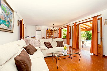A living room with a white couch and a glass coffee table