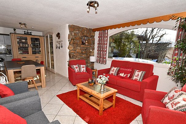 A living room with a red couch and two chairs
