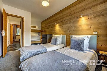 A bedroom with two beds and a sign that says mountain base knight frank