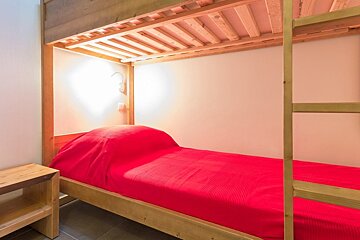 A bunk bed with a red blanket on it