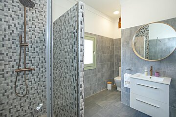 A bathroom with a toilet and a sink with a towel that says cm on it