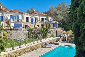 A large house with a swimming pool in front of it