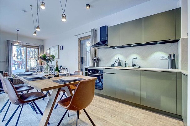 A bottle of champagne sits on a table in a kitchen