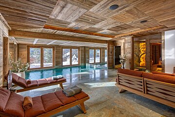 A large indoor swimming pool with a wooden ceiling